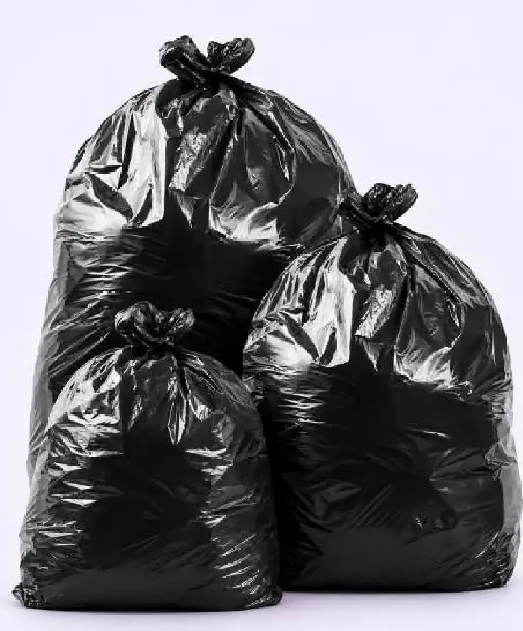 Tres bolsas de residuo negras y brillantes, llenas y atadas, de tres tamaños: la más grande atrás, la más chica adelante